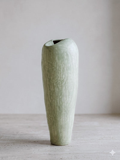 Minimalist pastel green tadelakt ceramic vase with an organic asymmetrical opening